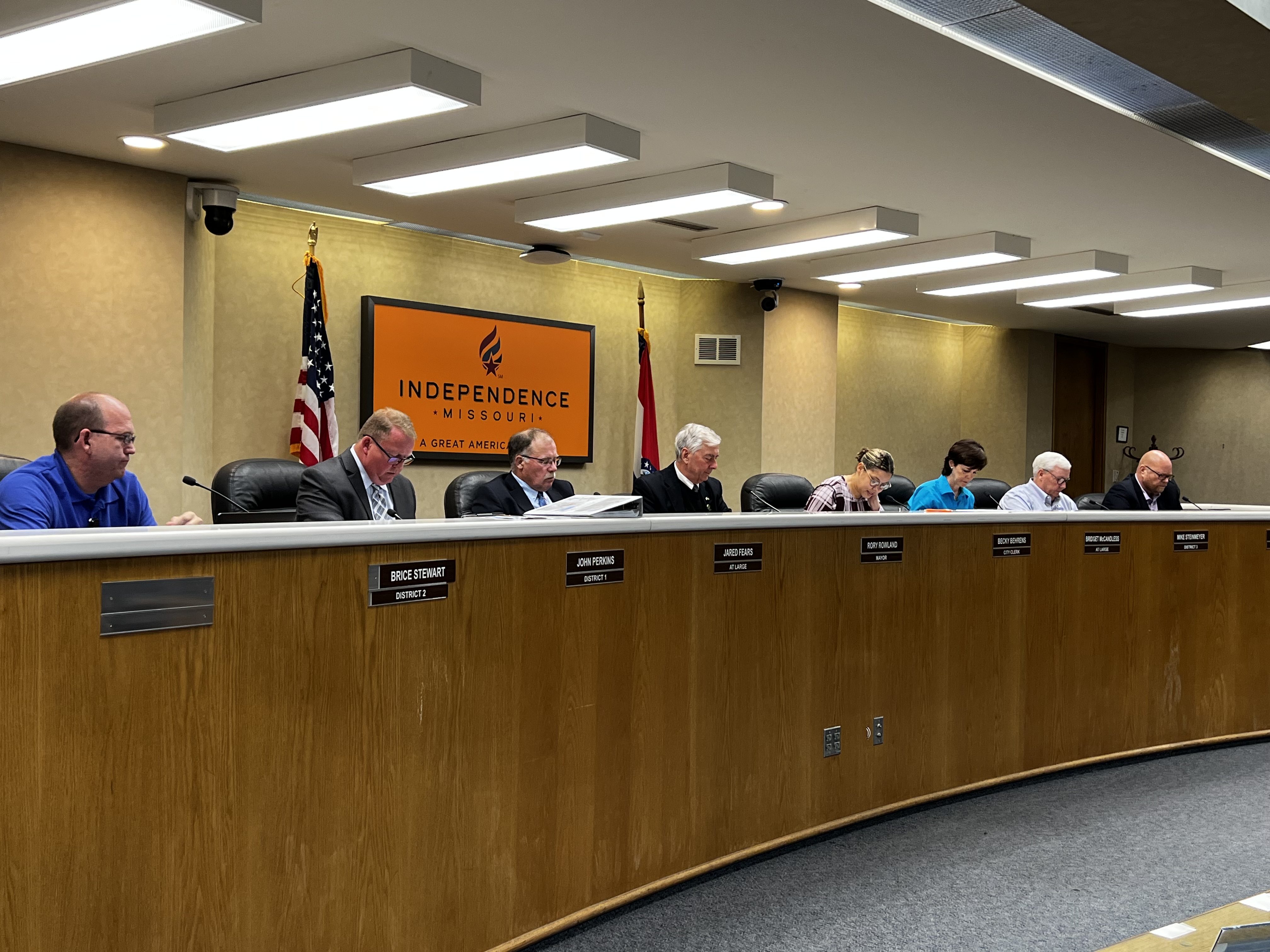 The seven members of the City Council and City Clerk sit behind the dais in the Council Chambers of Independence City Hall. 