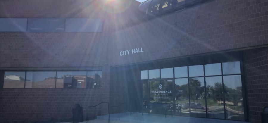 Independence City Hall, a brick building, is lit by the sun from behind