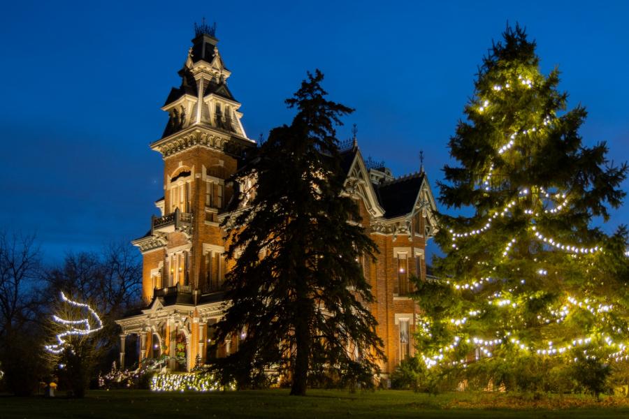 Side view exterior image of the Vaile Mansion with holiday lights on.