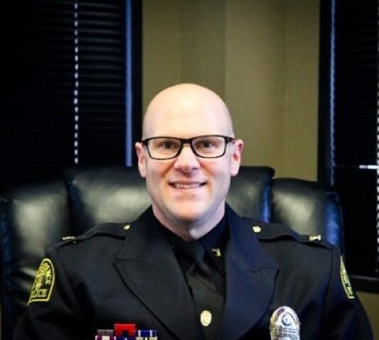 Interim Independence Police Chief Adam Dustman sits in uniform in his office. 