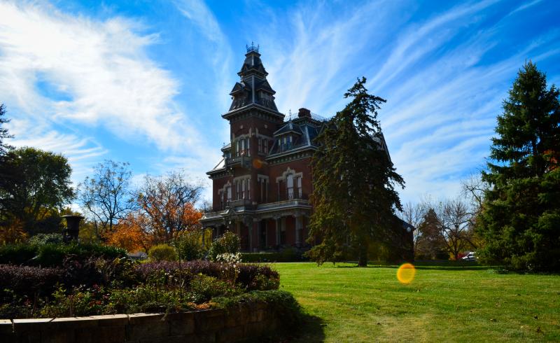 A side view of the Vaile Mansion in Independence, Missouri with blue skies and light wispy clouds in the background