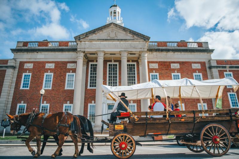 Pioneer Trails Adventures wagon with mules in front of the Independence Square Courthouse