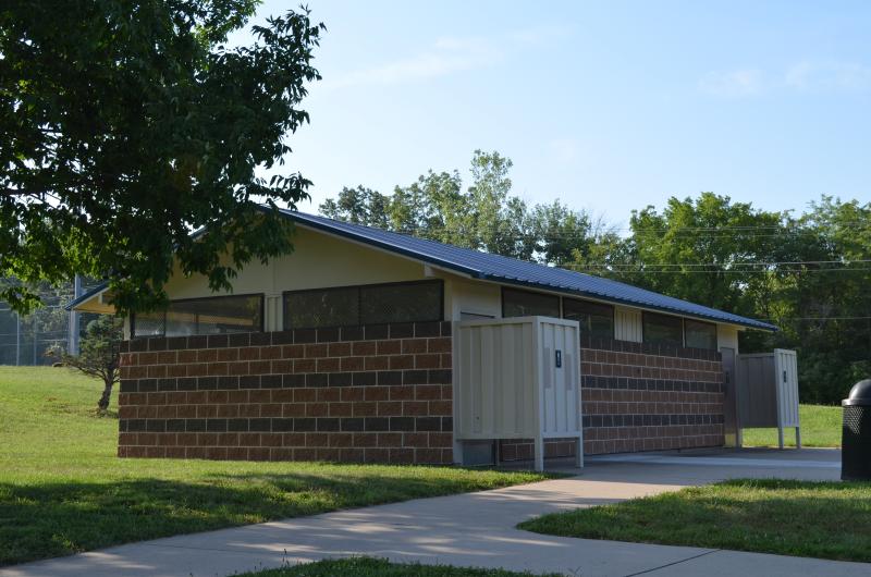 An image of the men's and women's restroom structure with a sidewalk in front of it at Santa Fe Park.