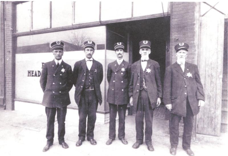 5 Police officers standing in front of building