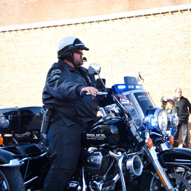 An Independence Police officer rides a motorcycle along Independence Halloween Parade route. 